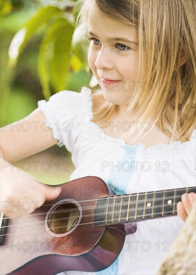 Caucasian girl playing ukulele