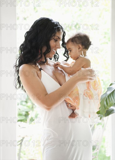 Mixed Race mother holding baby daughter