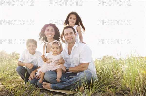 Portrait of Mixed Race family sitting in grass