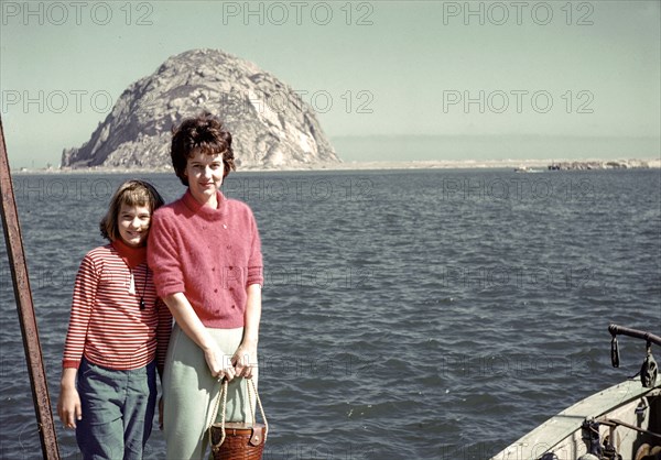 Caucasian mother and daughter posing near ocean