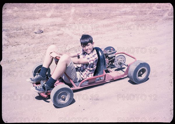 Portrait of Caucasian boy sitting on go-cart