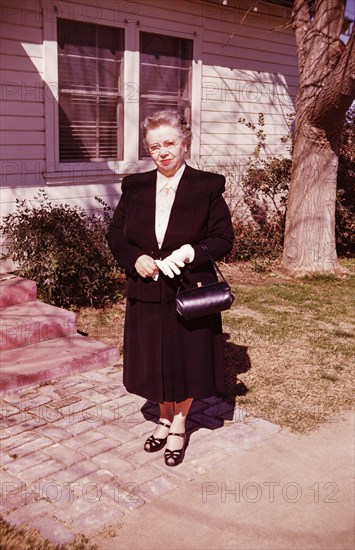 Portrait of smiling Caucasian woman standing near front stoop