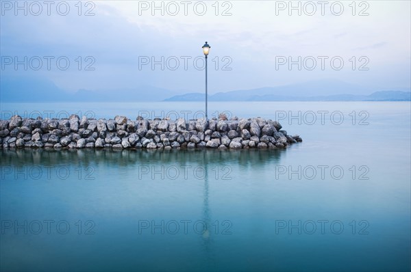 Lamp on stone breakwall in ocean