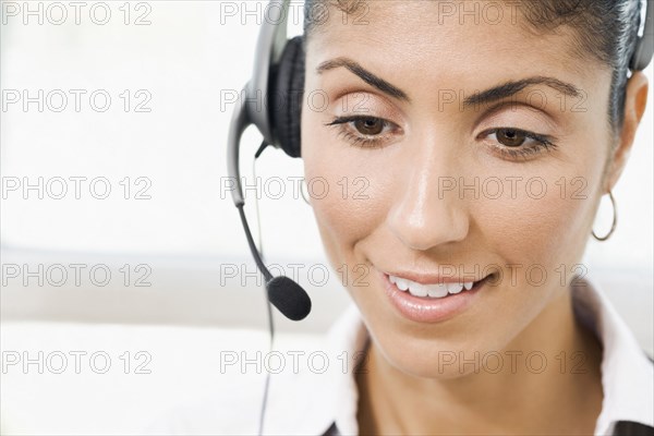 Mixed Race businesswoman wearing telephone headset