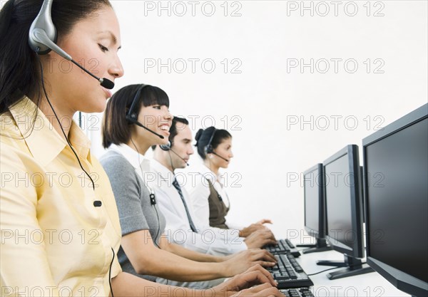 Customer service representatives wearing headsets using computers