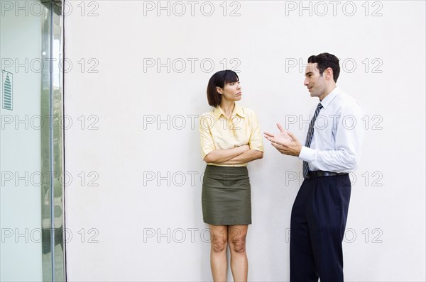 Business people talking near wall