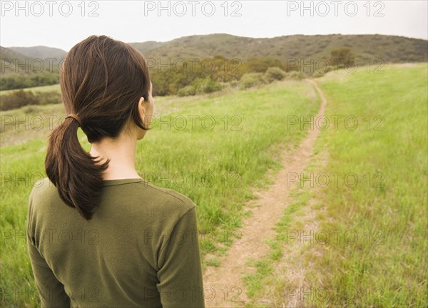 Mixed Race woman standing on path in field