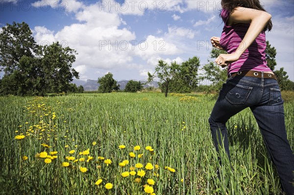 Mixed Race woman running in field