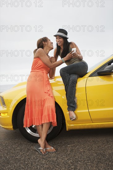 Friends sitting on yellow car