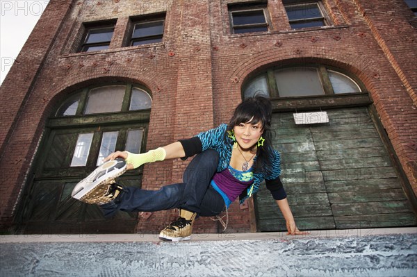 Chinese woman breakdancing in urban area
