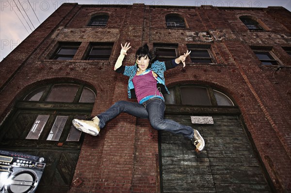 Chinese woman breakdancing in urban area