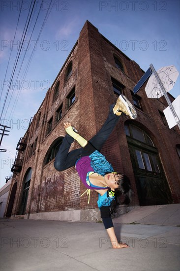 Chinese woman breakdancing in urban area