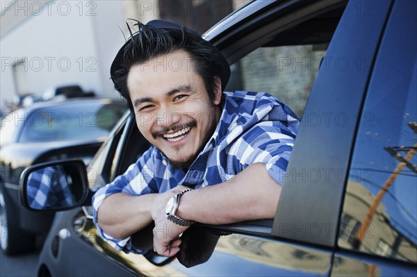 Smiling mixed race man in compact car