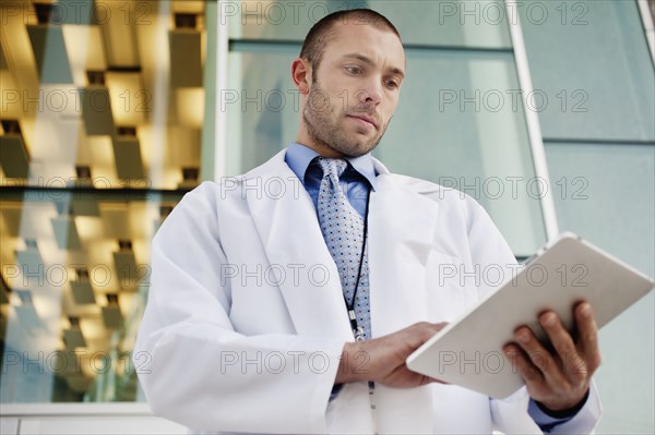 Doctor using digital tablet outdoors