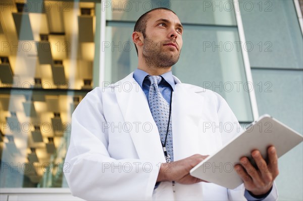 Doctor using digital tablet outdoors