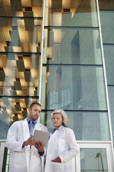 Doctor's using digital tablet outdoors