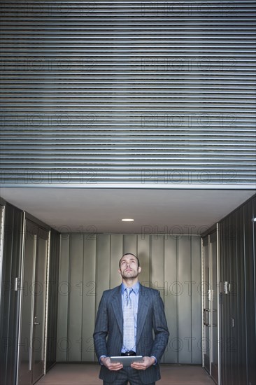 Businessman using digital tablet in corridor