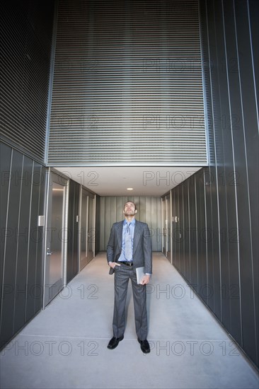 Businessman holding digital tablet in corridor