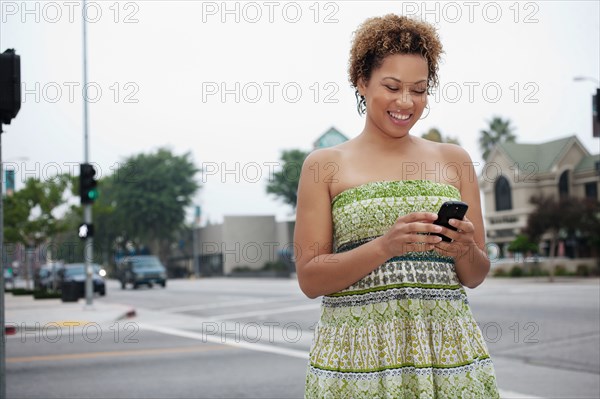 African American woman text messaging on cell phone