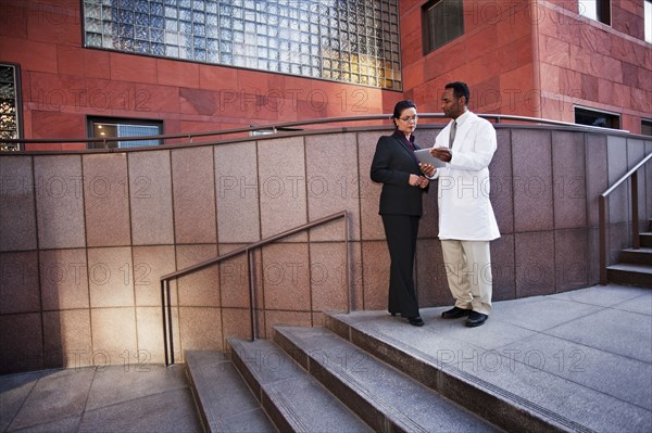 African American doctor and businesswoman using digital tablet