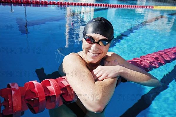 Competitive swimmer leaning on rope in swimming pool