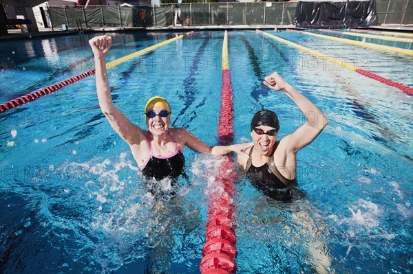 Competitive swimmers cheering in swimming pool