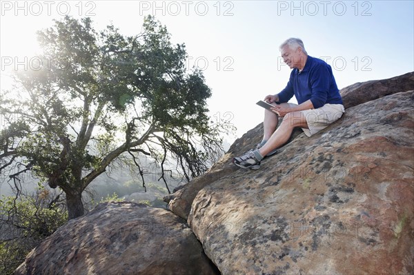 Caucasian man using digital tablet in remote area