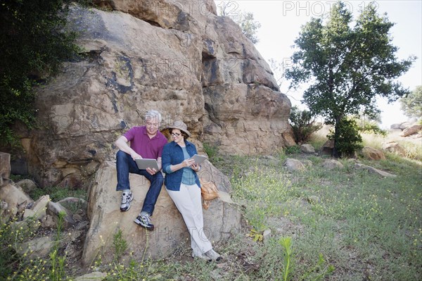 Caucasian couple using digital tablet in remote area