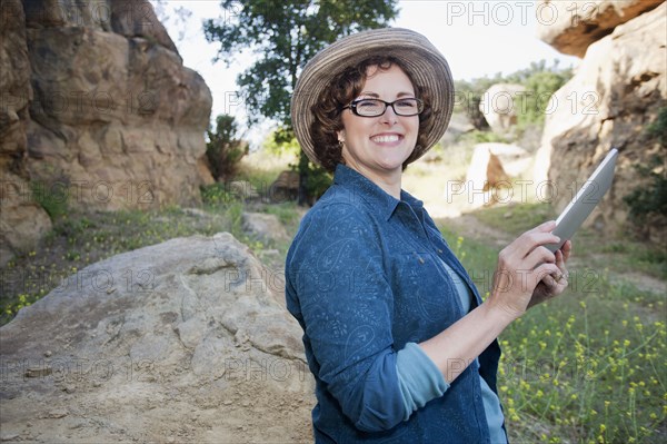 Caucasian woman using digital tablet in remote area