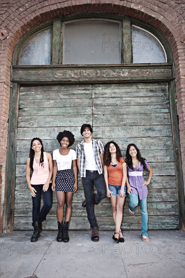 Friends leaning against wooden garage door