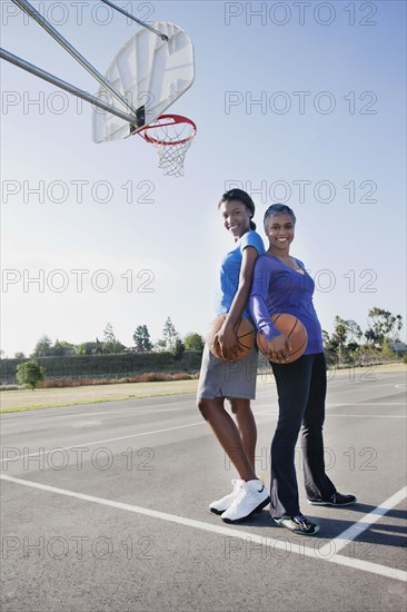 Mother and daughter playing basketball