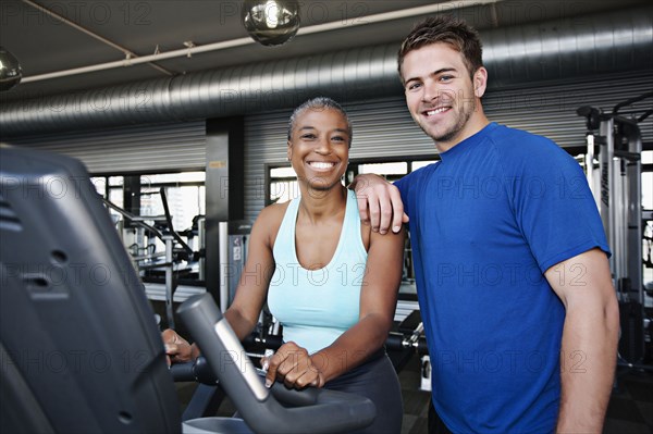 Woman with personal trainer in health club