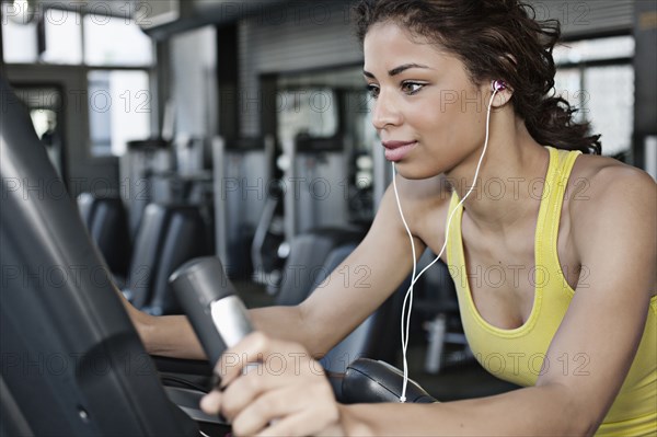 Mixed race woman exercising in health club