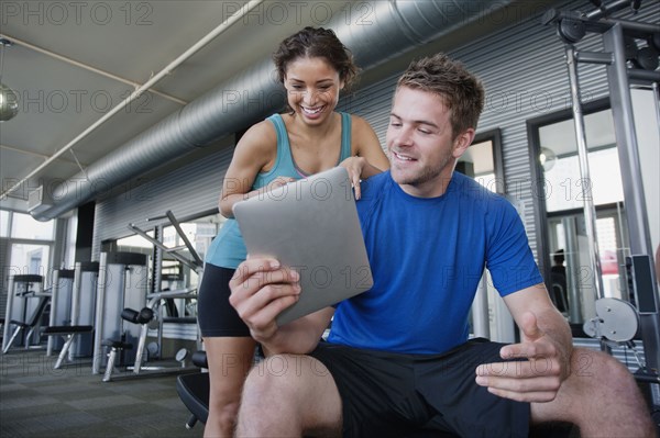 Couple using digital tablet in health club