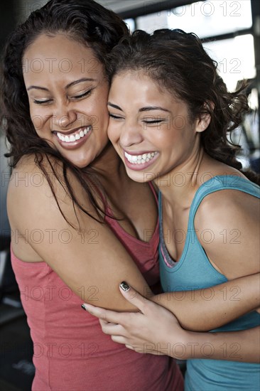 Smiling women hugging in health club