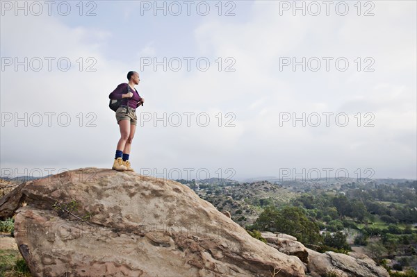 Black hiker standing on rock in remote area