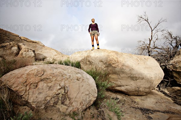 Black woman standing on top of rock