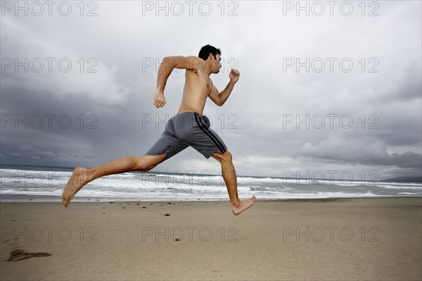 Young man running on beach