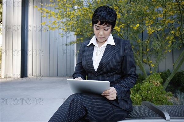 Businesswoman using digital tablet outdoors