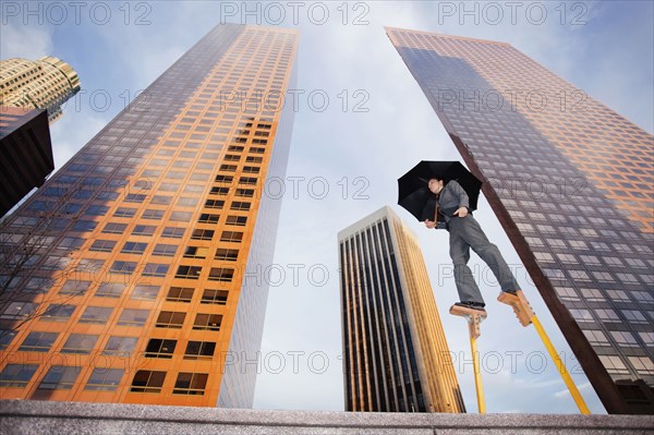 Caucasian businesswoman walking on stilts in urban environment