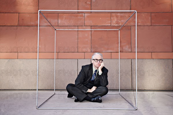 Caucasian businessman sitting inside of box