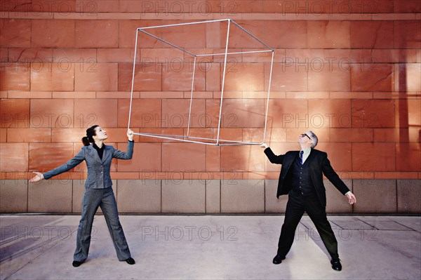 Caucasian business people lifting metal box