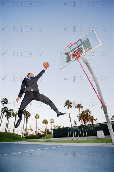 Businessman playing basketball outdoors