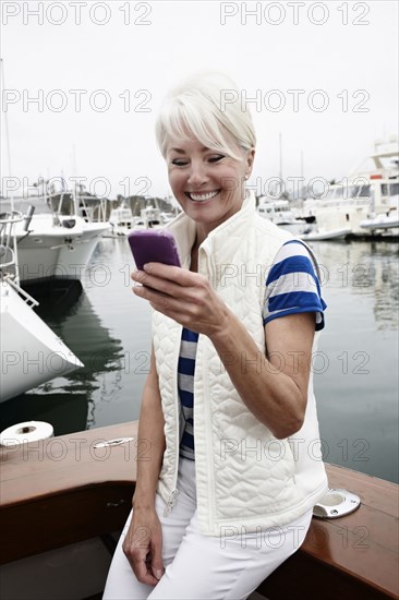 Woman using cell phone in marina