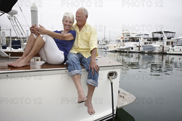Couple relaxing on boat in marina