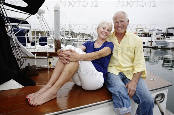 Couple relaxing on boat in marina