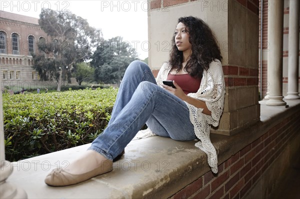 Mixed race student sitting on campus