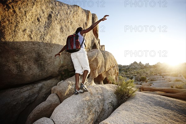 Woman hiking over large rocks