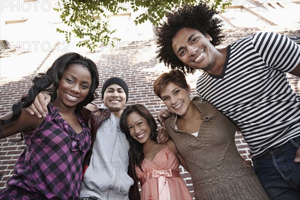 Smiling friends standing together hugging