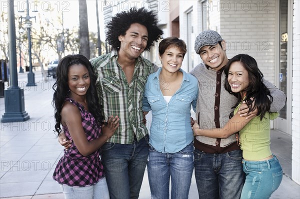 Smiling friends standing together hugging